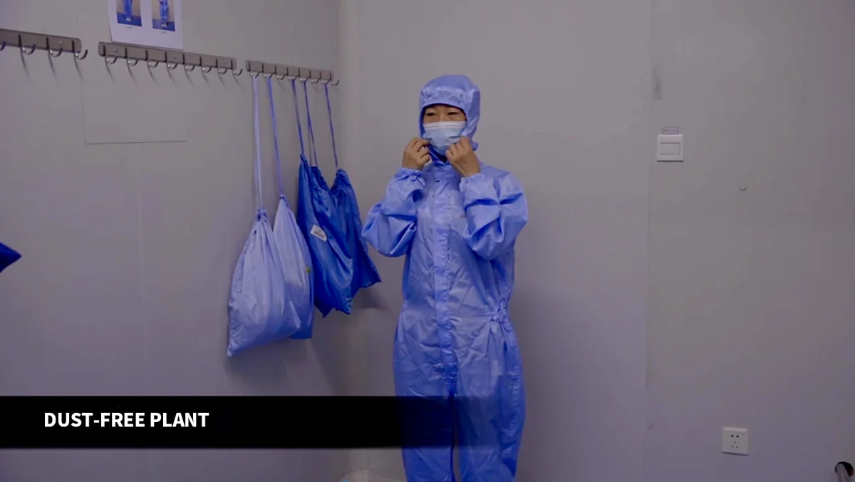Worker preparing protective clothing in the production changing area